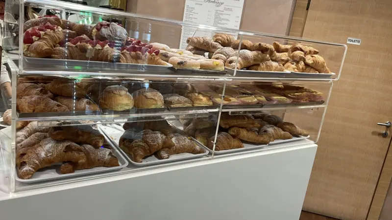 Vetrina della caffetteria Martinazzo con croissant e brioche artigianali farciti, pronti per la colazione